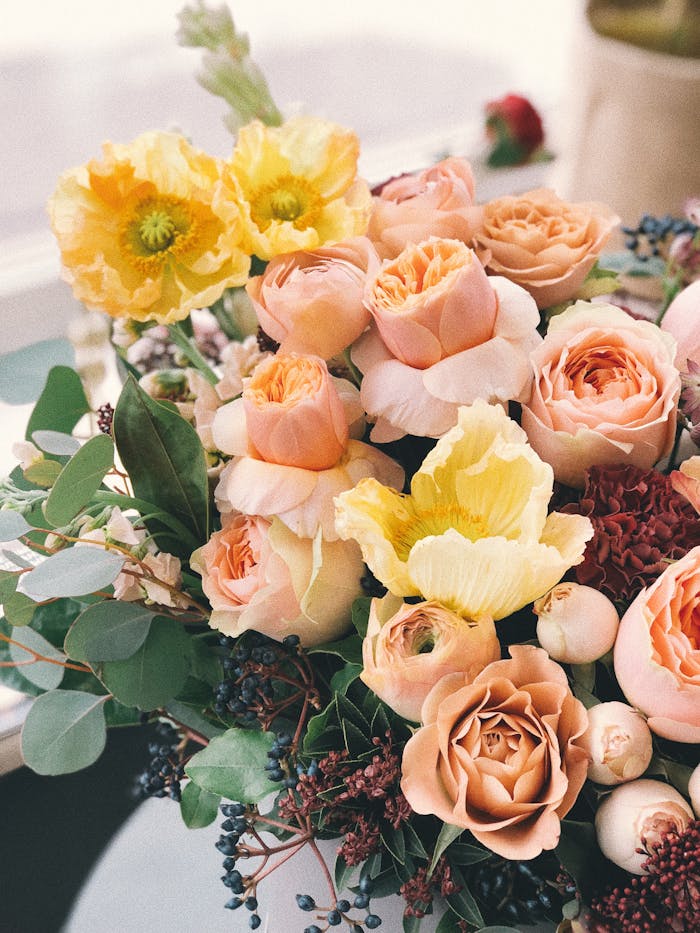 A beautiful floral bouquet featuring roses and poppies, perfect for weddings or celebrations.